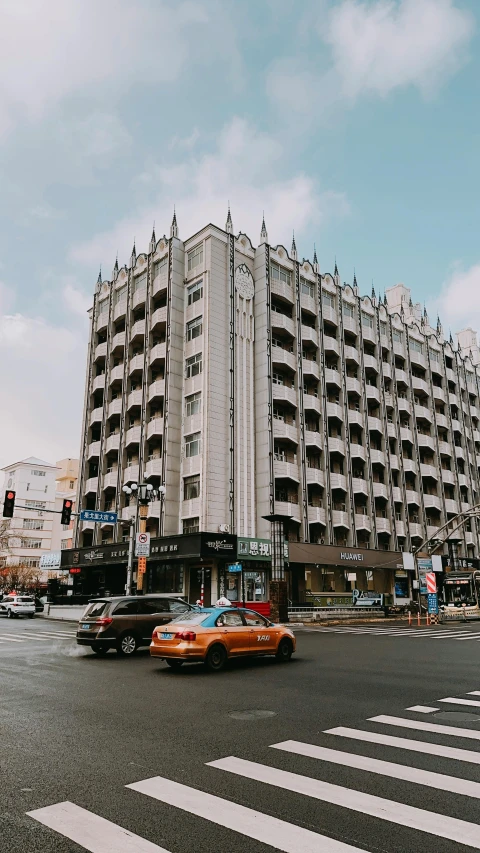 a building with many stories and cars parked in front of it