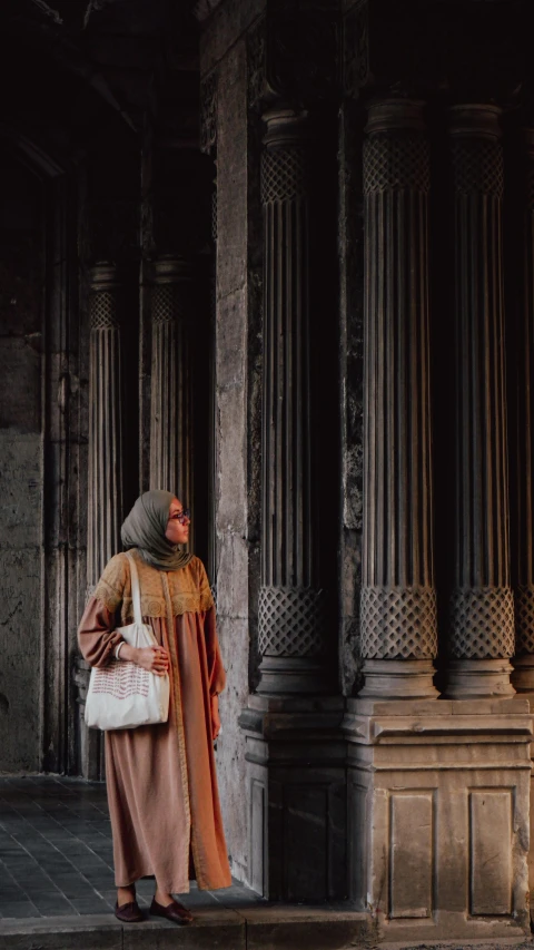 a person walking outside of a building carrying a white handbag