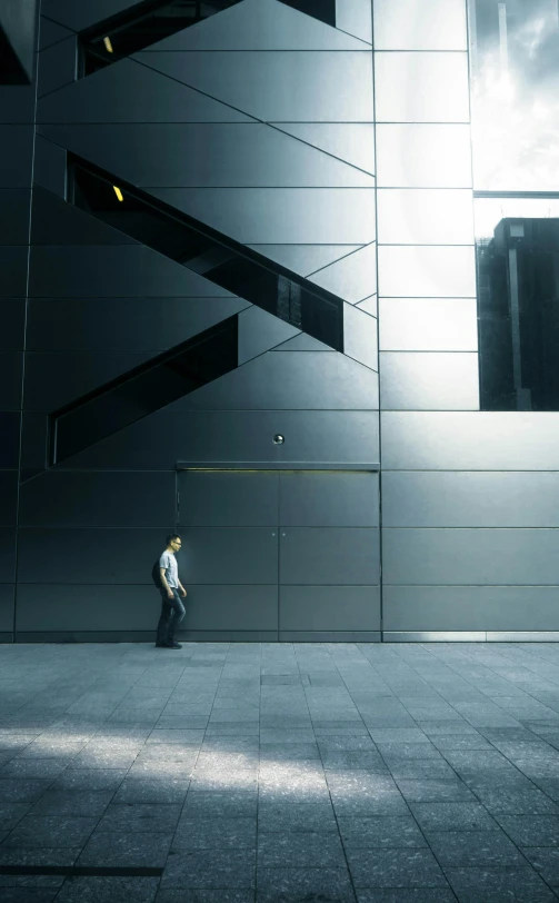 man walking down the sidewalk in front of a building