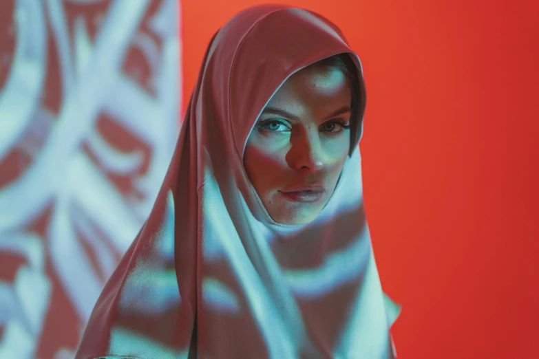 a woman in white standing next to a red wall