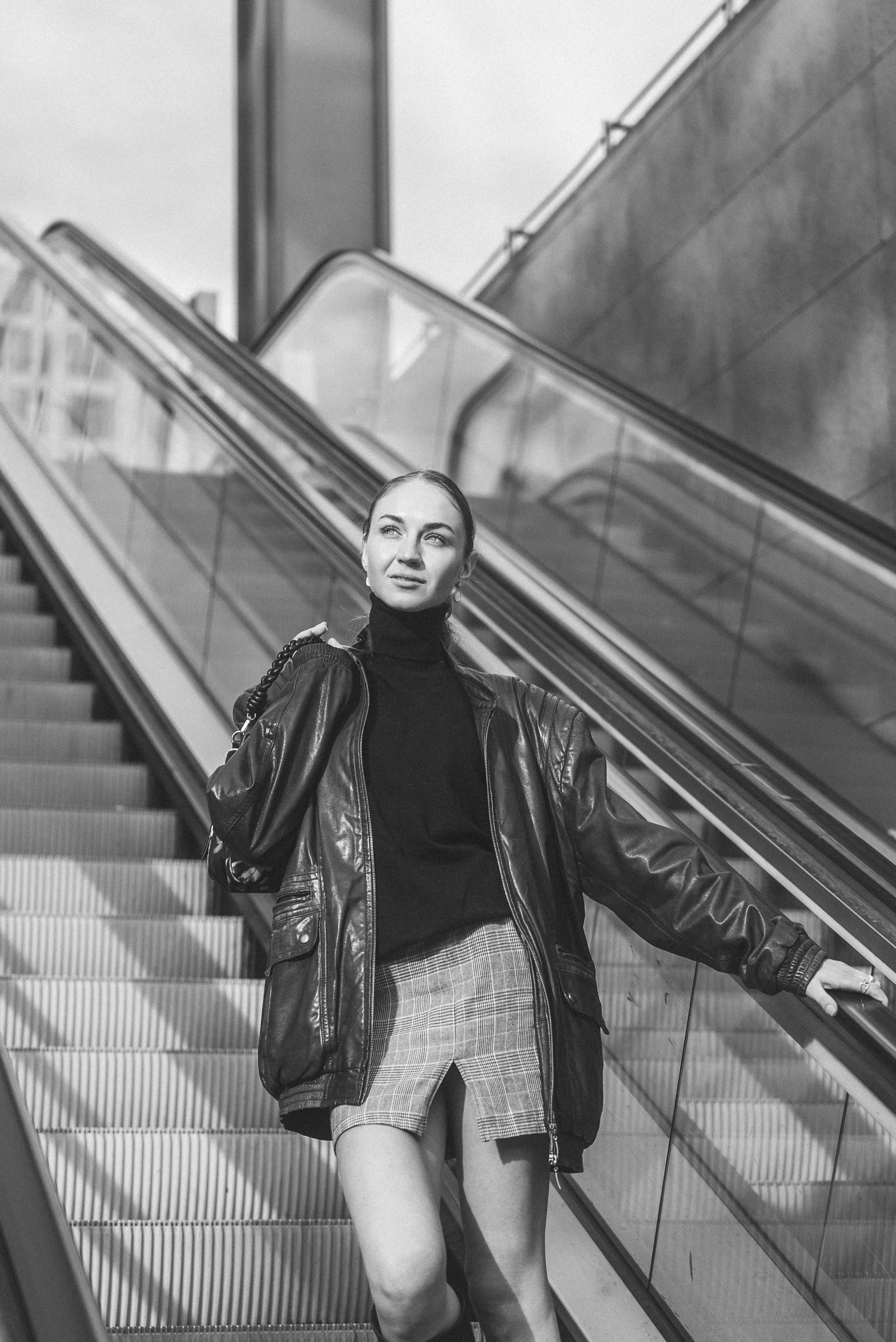 a woman is standing on the escalator while walking up