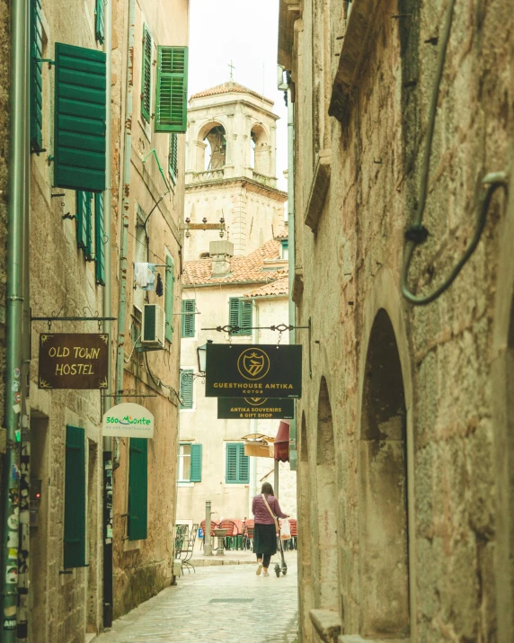 some people walk down an alley way next to a building