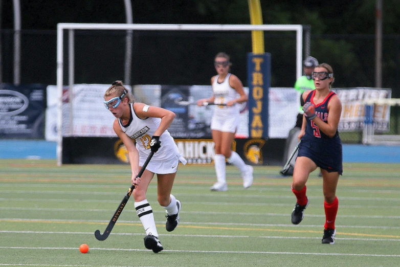 two girls are playing a game of field hockey