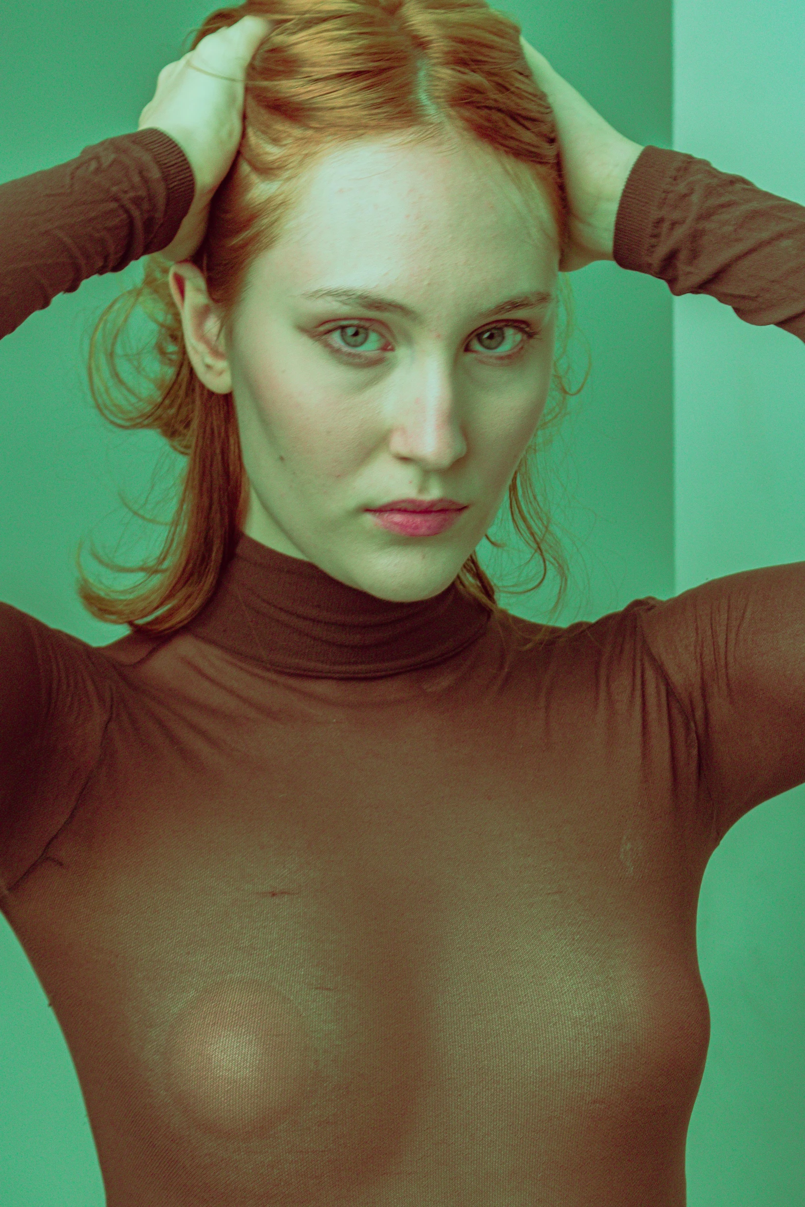 a young woman in an extremely tight, turtle - neck top has her hands behind her head