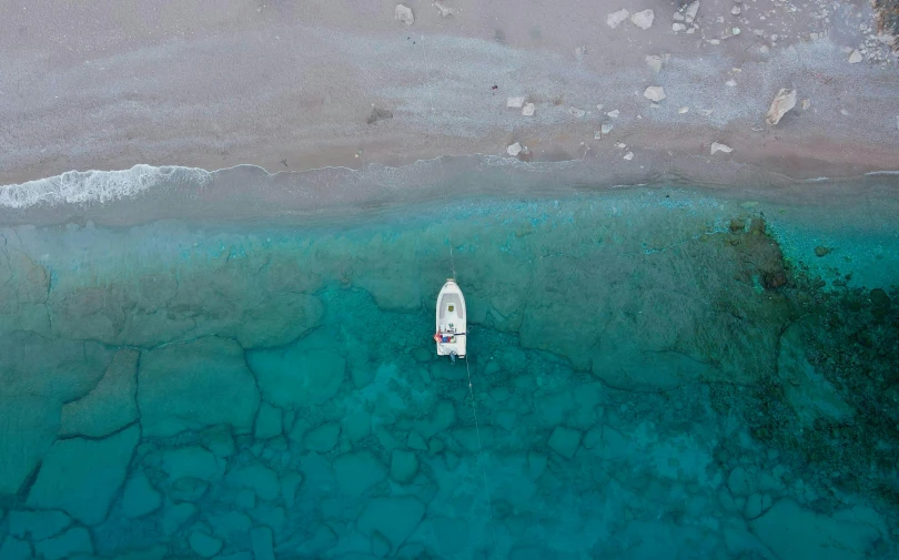 an aerial view of a beach with a boat in the water