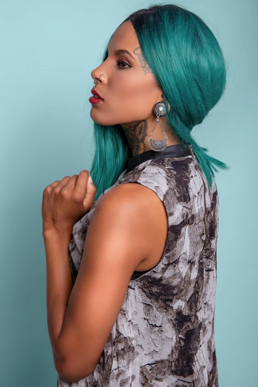 a black woman with green hair and tattoos