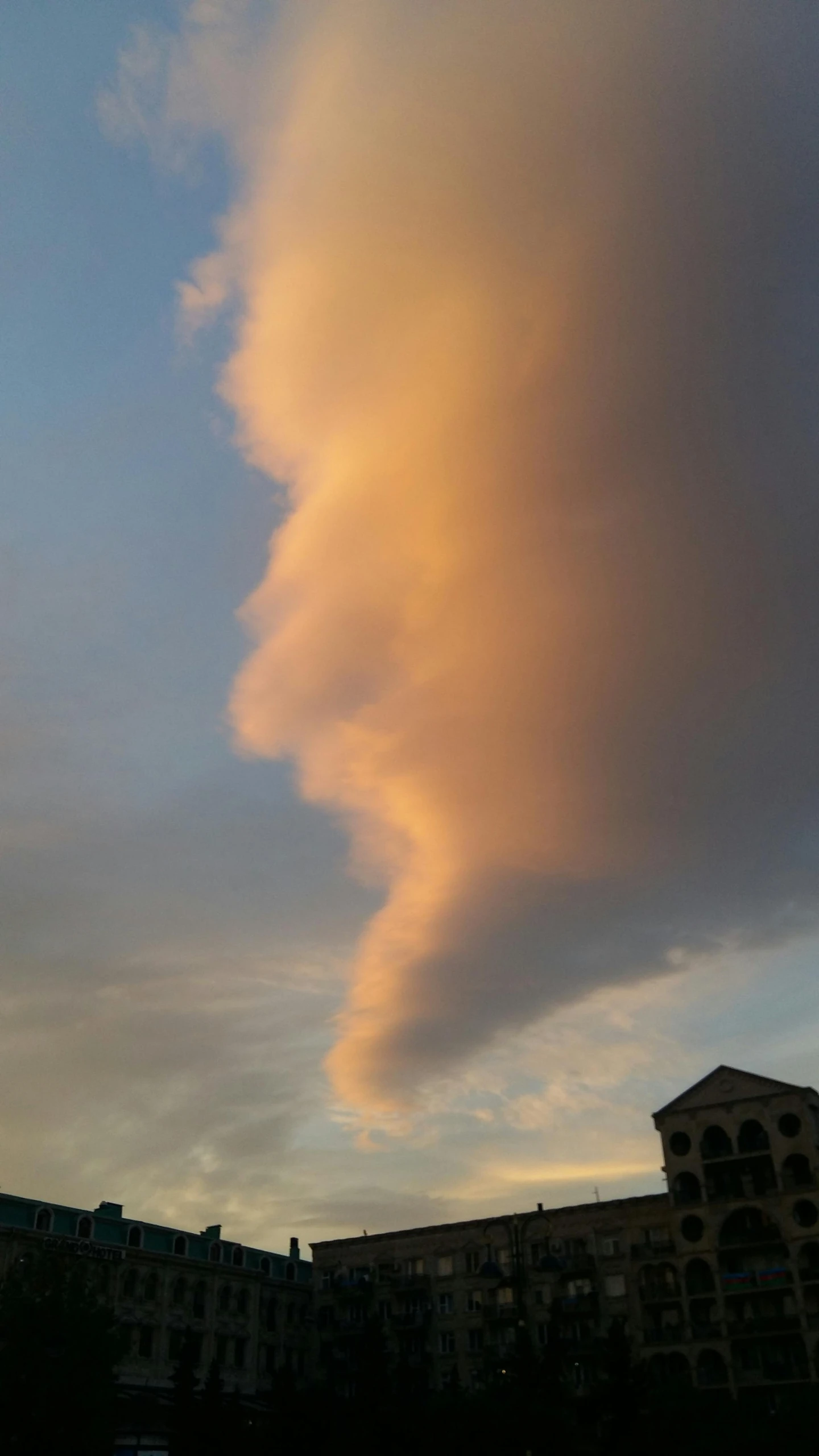 a pink cloud that is coming over a city