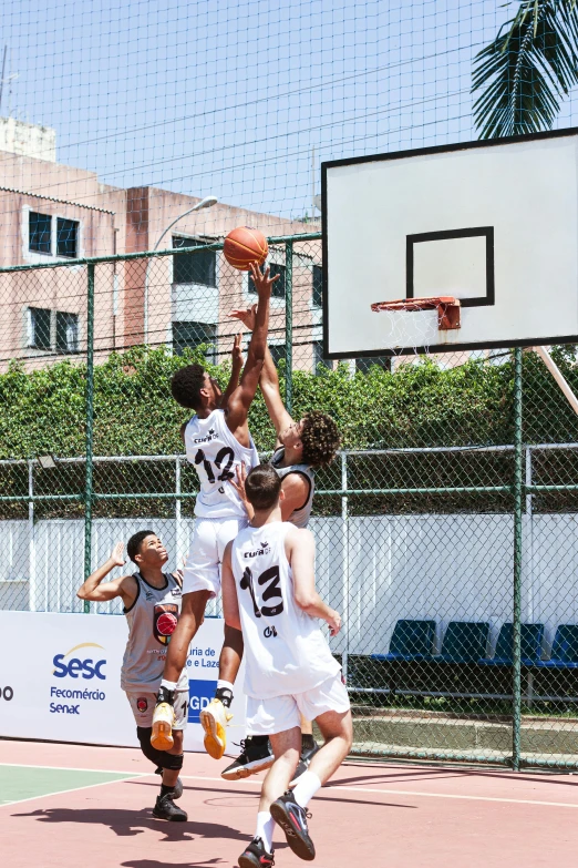 a group of boys playing basketball in the outdoor