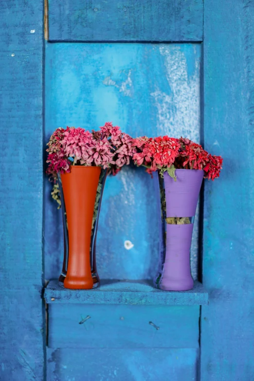 three vases that have flowers placed on the window sill