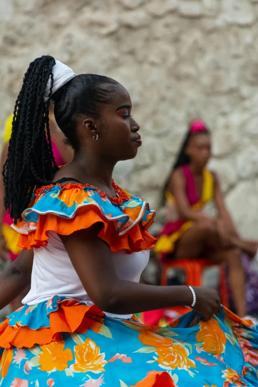 women in a colorful dress and flower - print hair