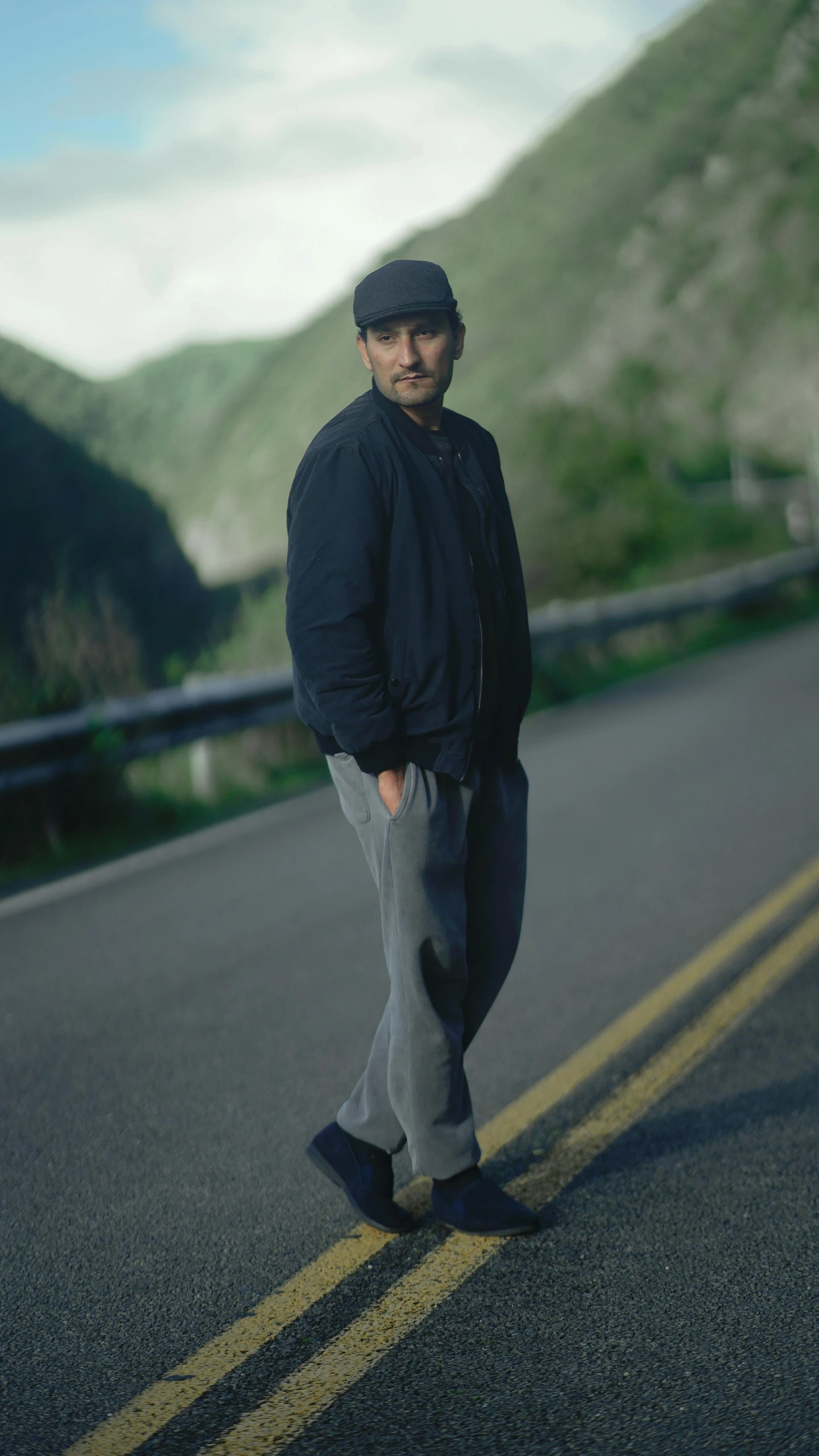 the man stands alone on a mountain road