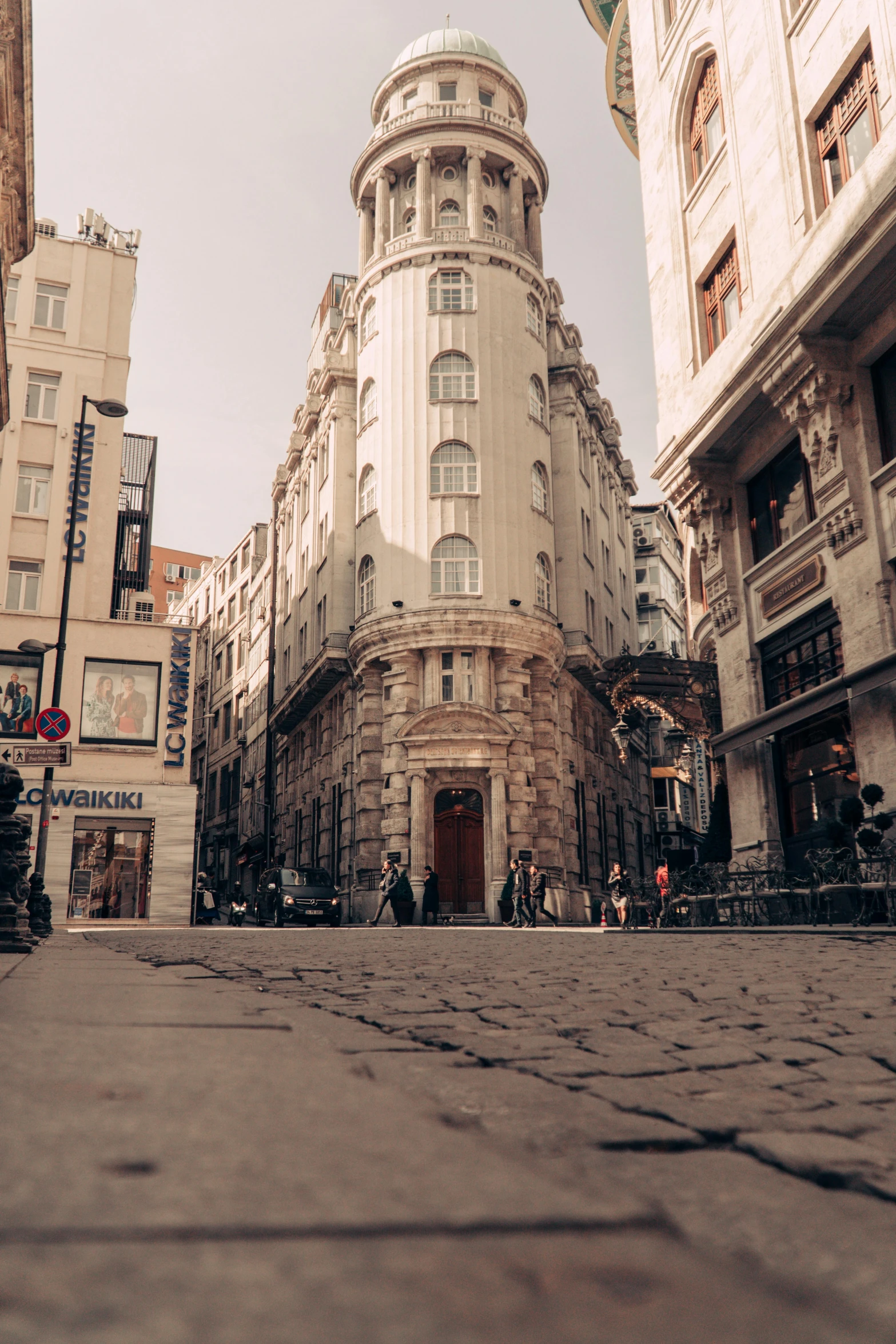 a stone paved street with pedestrians in it