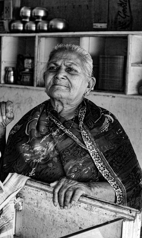 an old woman is looking at the camera while sitting