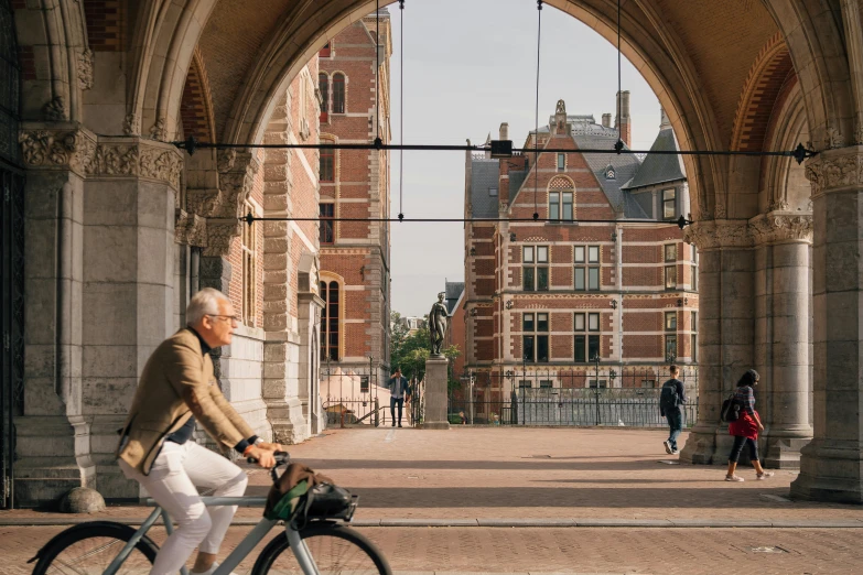 a man riding his bicycle through an old gate