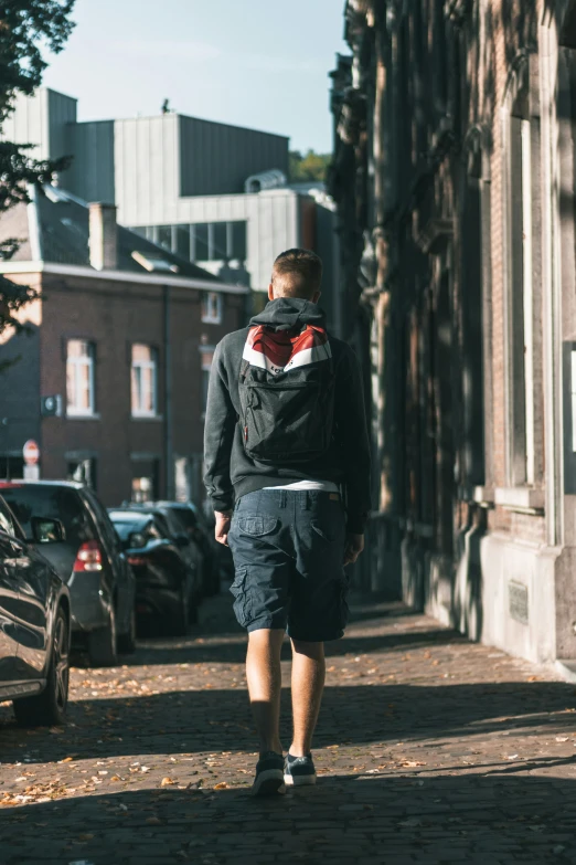 a man walking down the street holding a backpack