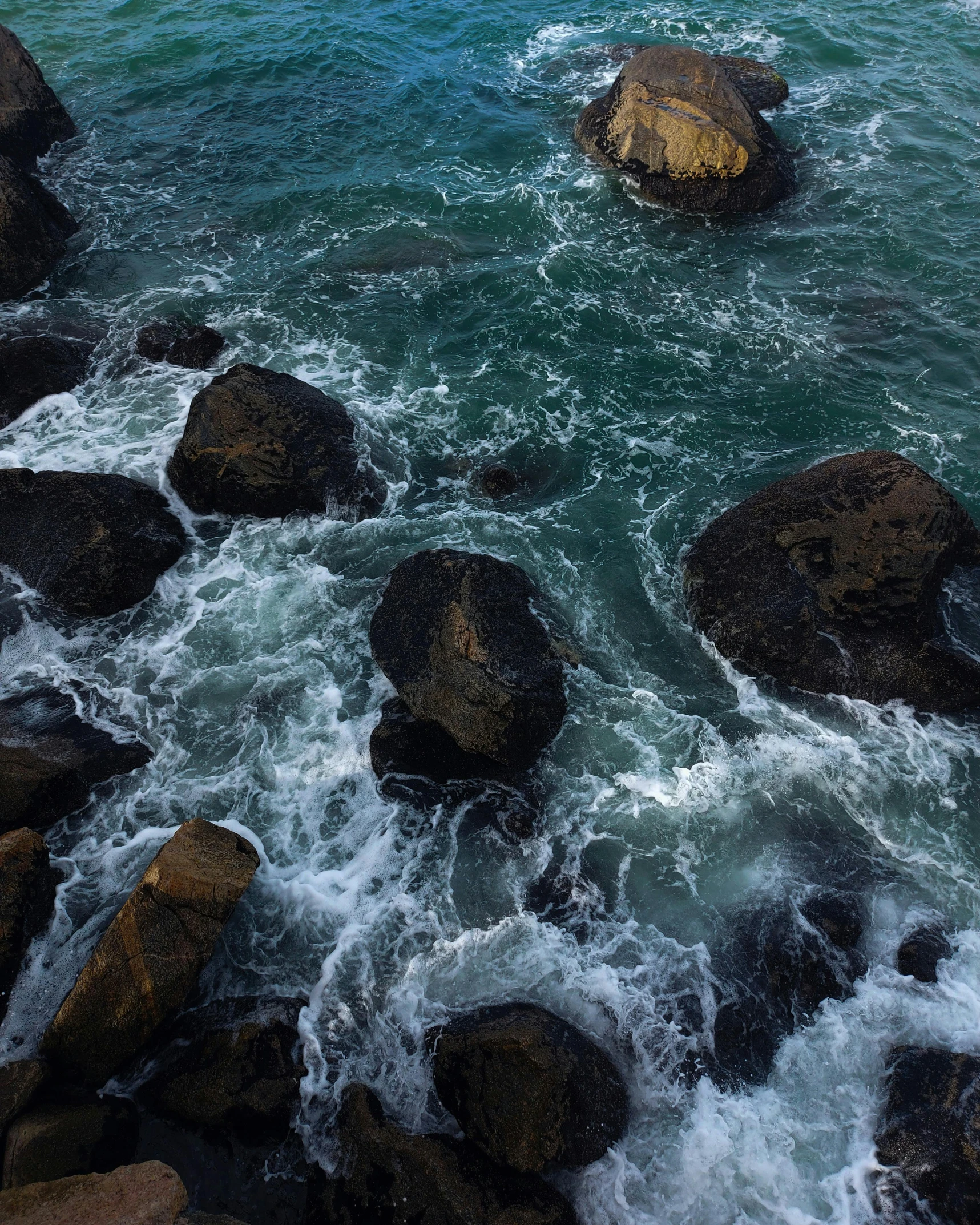 the view of rocks on the ocean from a cliff