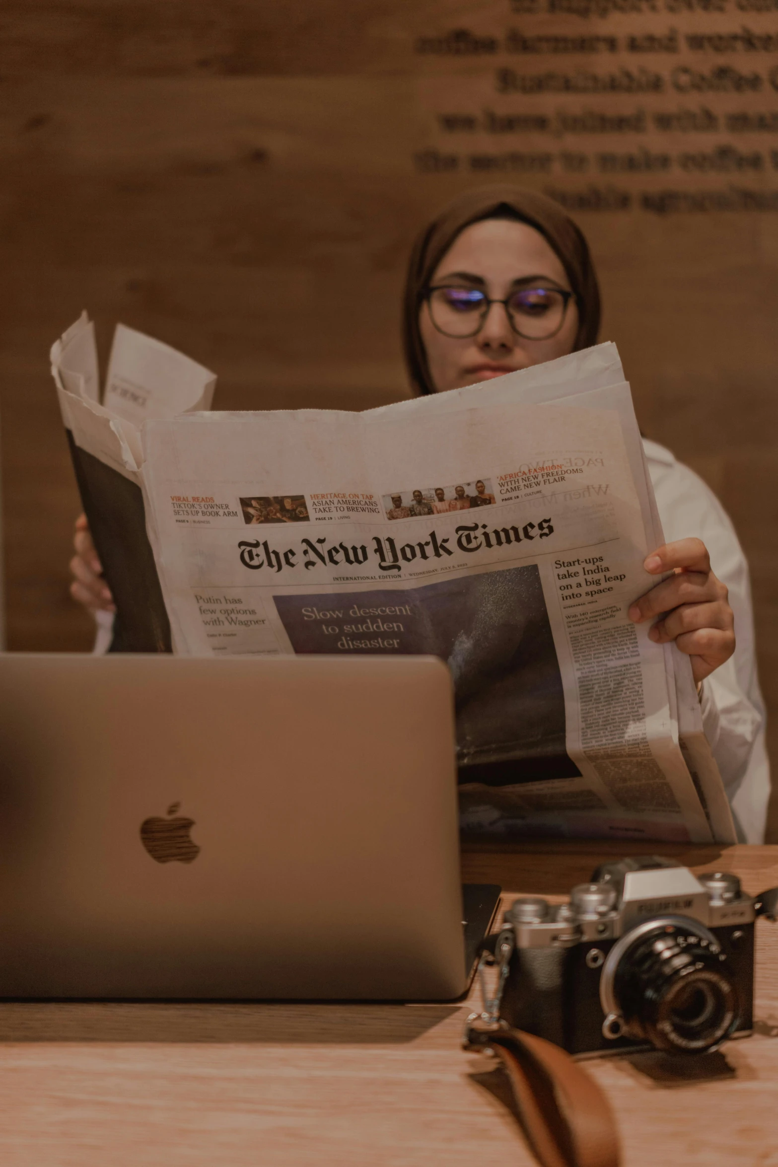 a woman looking at her laptop while reading the news