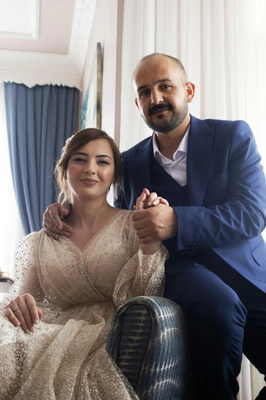 two people sitting down on the chair posing for a po