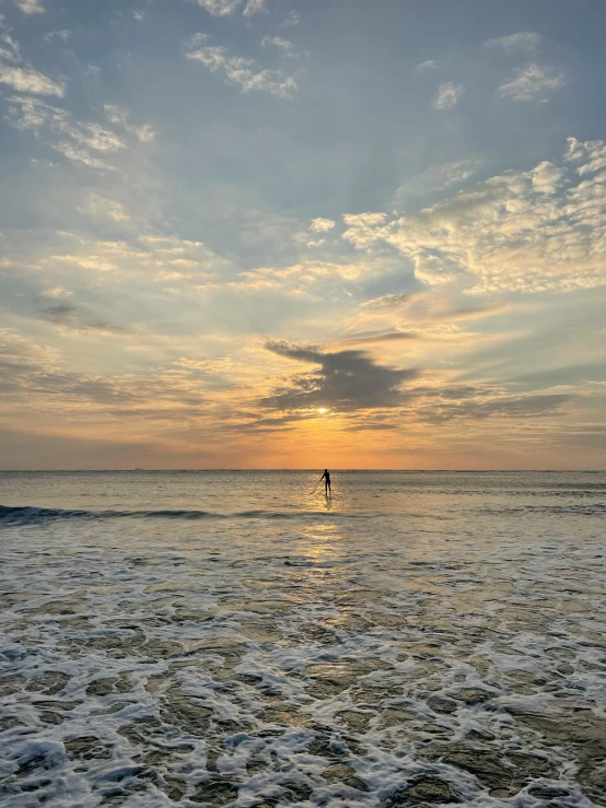 the ocean and sky with some surfers near by