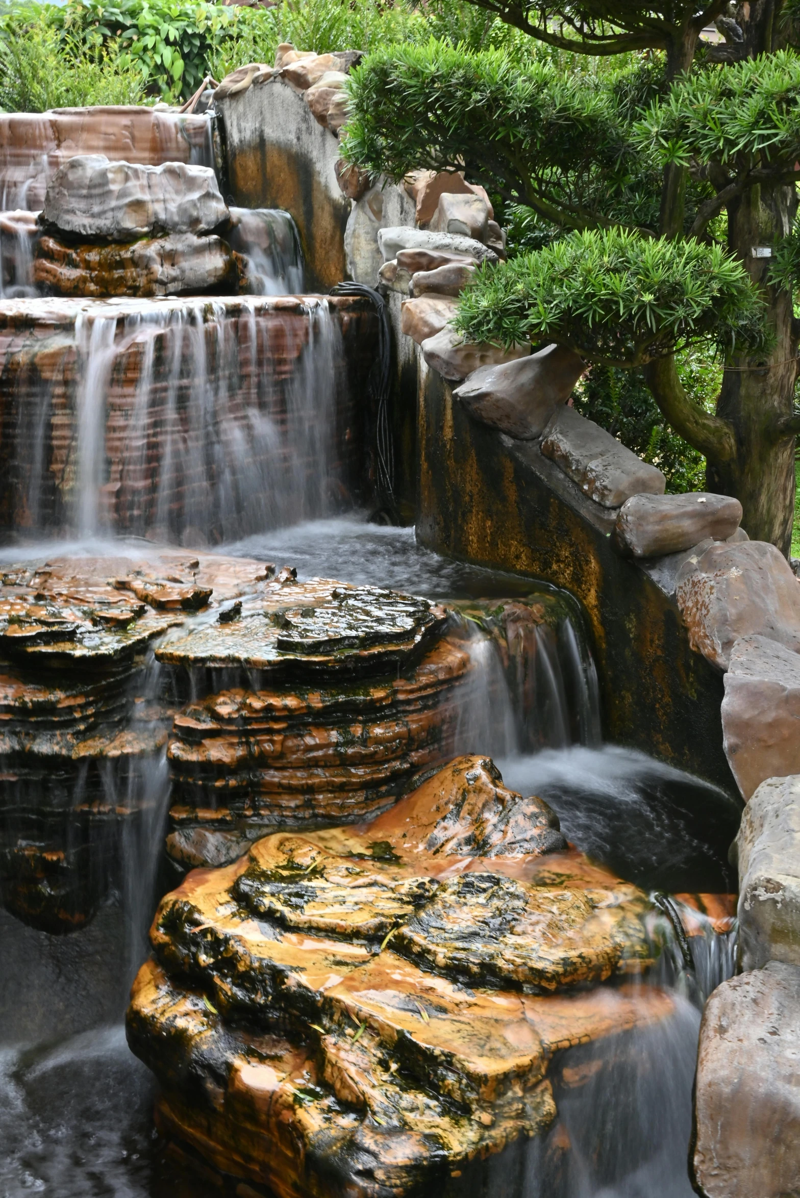 a large waterfall is coming down the side of a hill