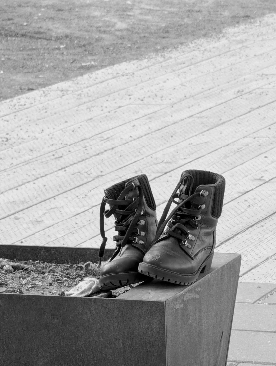 a black and white pograph of an unpaved pair of boots sitting in a rectangular box