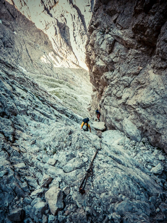 two men hiking up a rocky mountain side