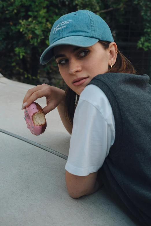 a female looking in the direction as she leans on her skateboard