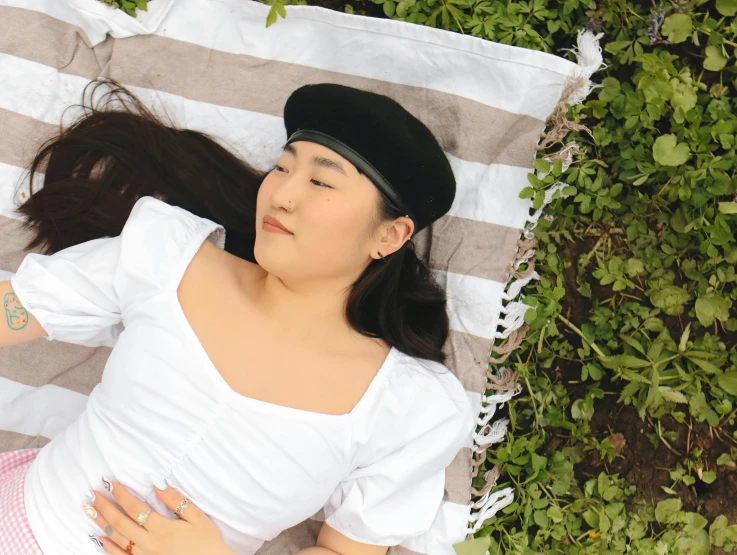 a woman wearing white laying on top of a blanket