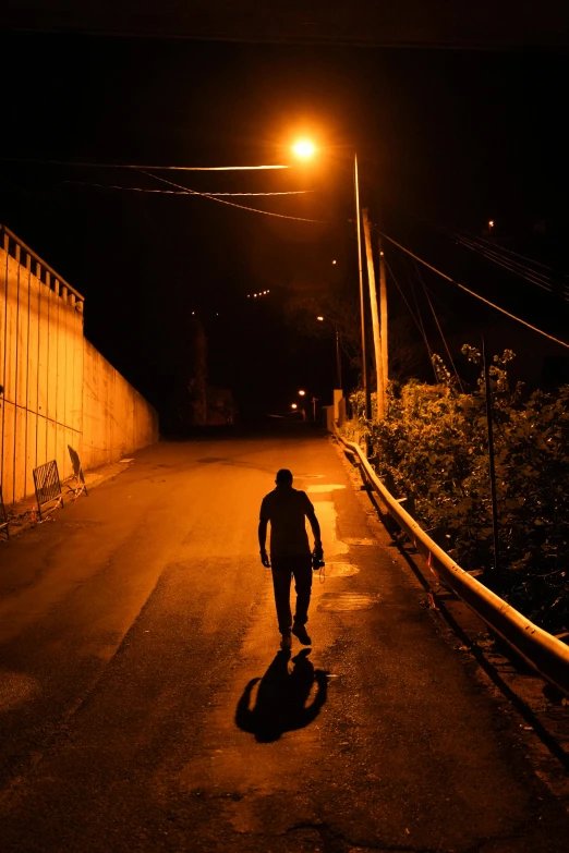 a man with a skateboard standing on an alley way