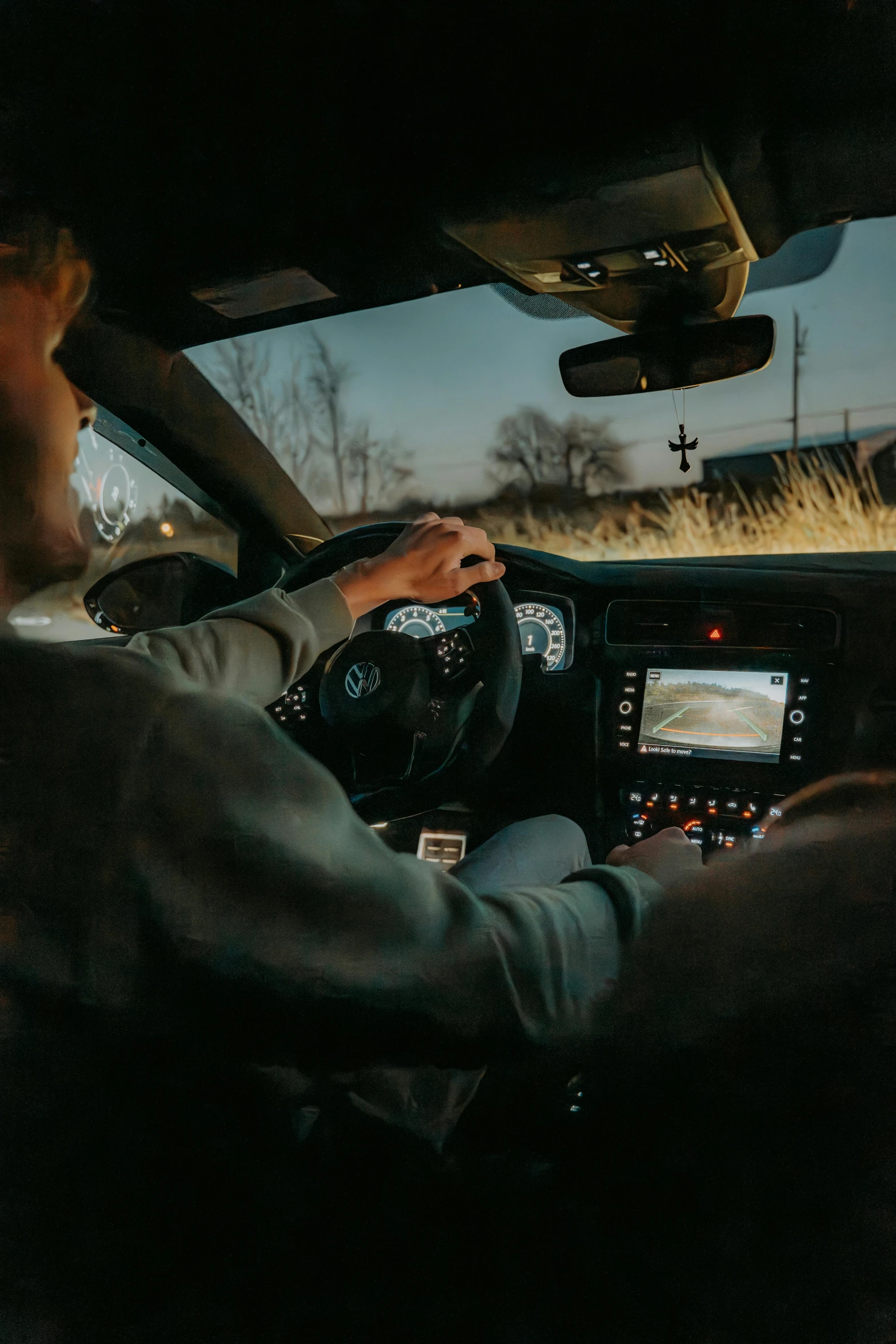 a man driving in a car at sunset