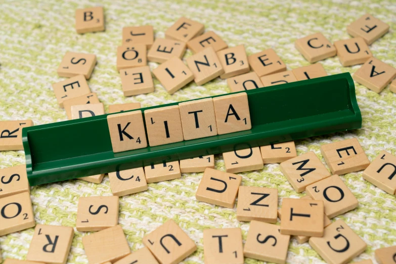 a keyboard is on the floor with scrabbles spelling out kita