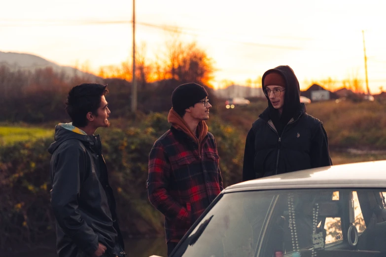 three people are standing near a van on a road