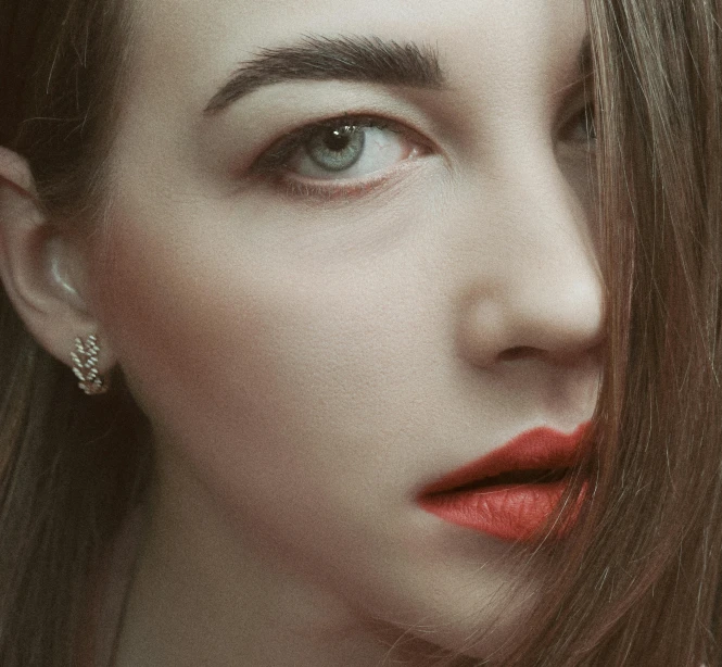 a girl with red lipstick looking to the side