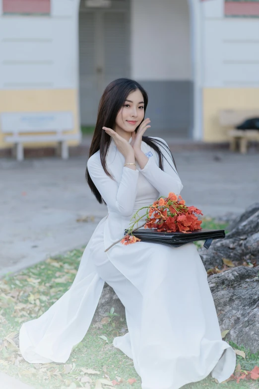 a beautiful young lady posing for the camera while holding a flower