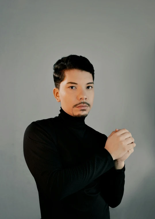 a man posing for a picture wearing a black turtleneck