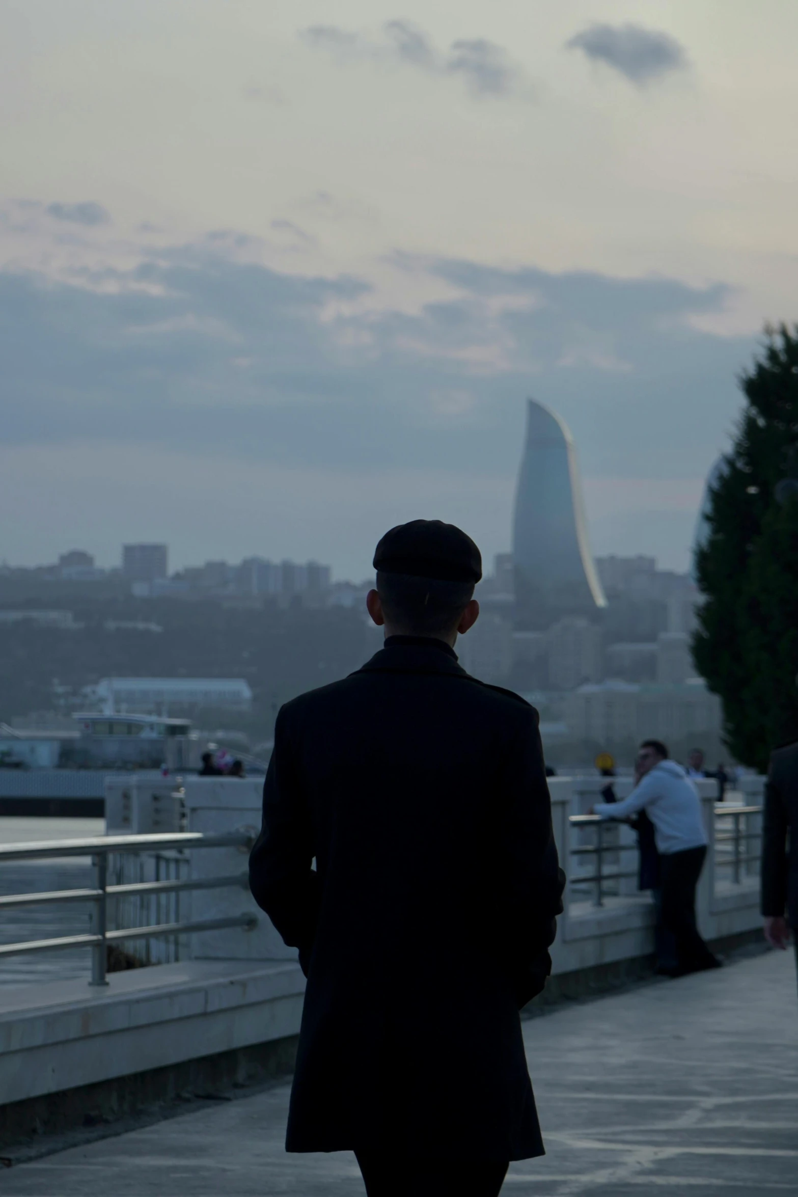 man walking with suit and tie next to a body of water