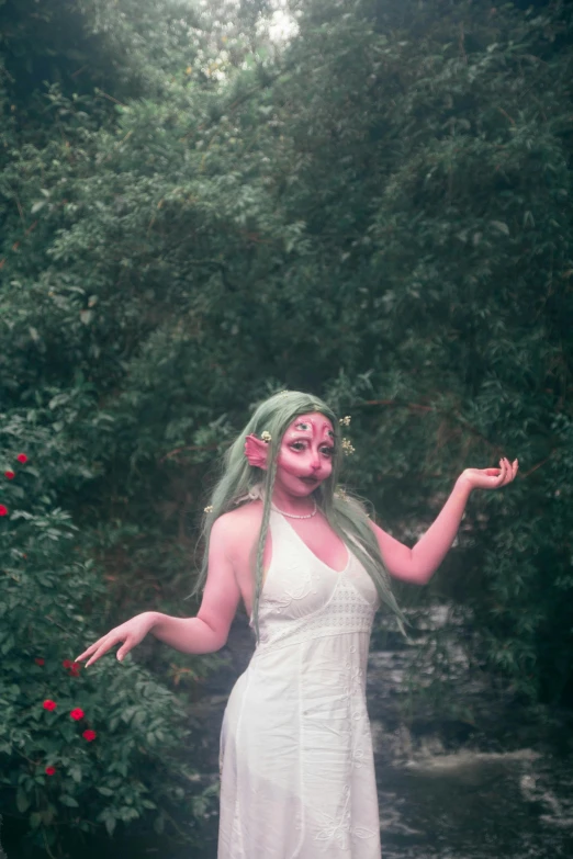 a woman standing in the middle of a forest with vines and flowers