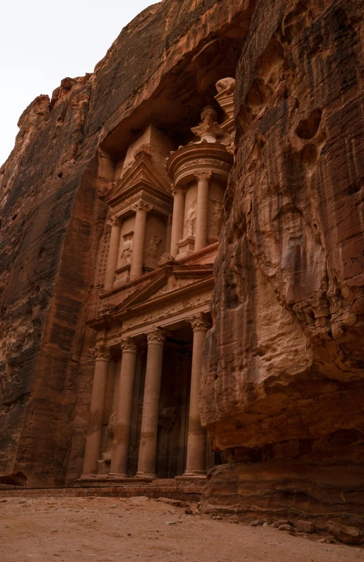 people are standing next to some rocks and pillars