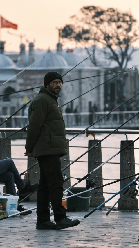 a man in a hat standing on the dock