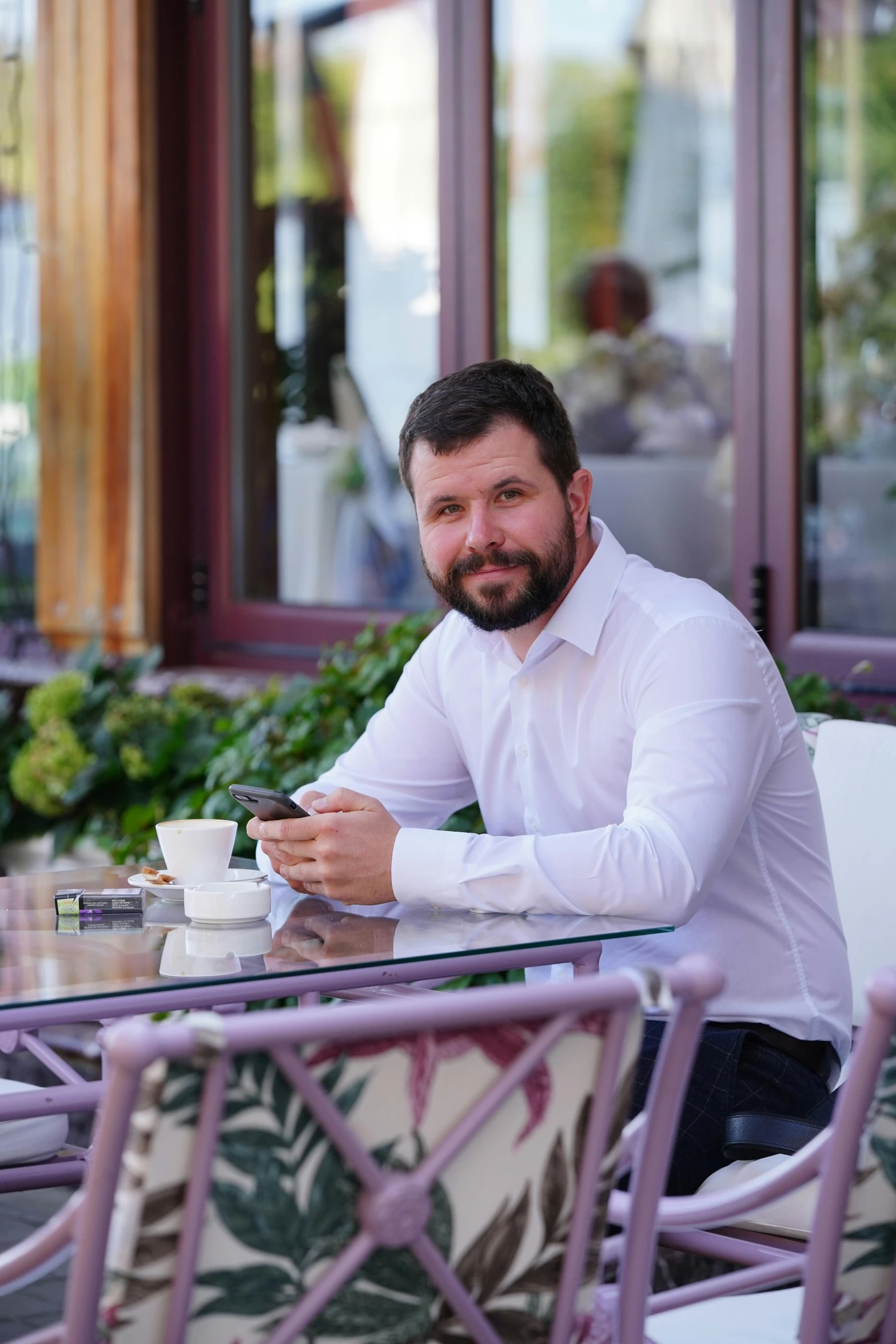 a man in a shirt and tie drinking coffee at a restaurant