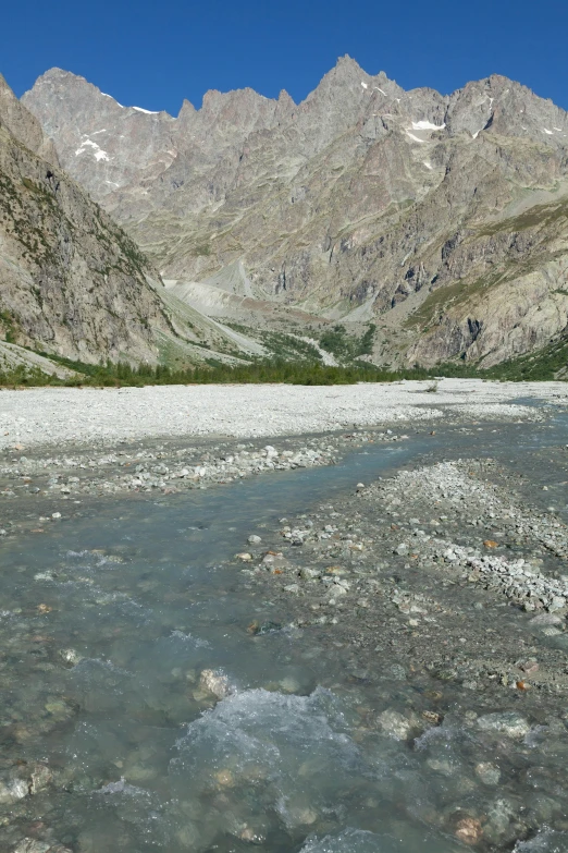 a scenic view of a small river surrounded by mountains