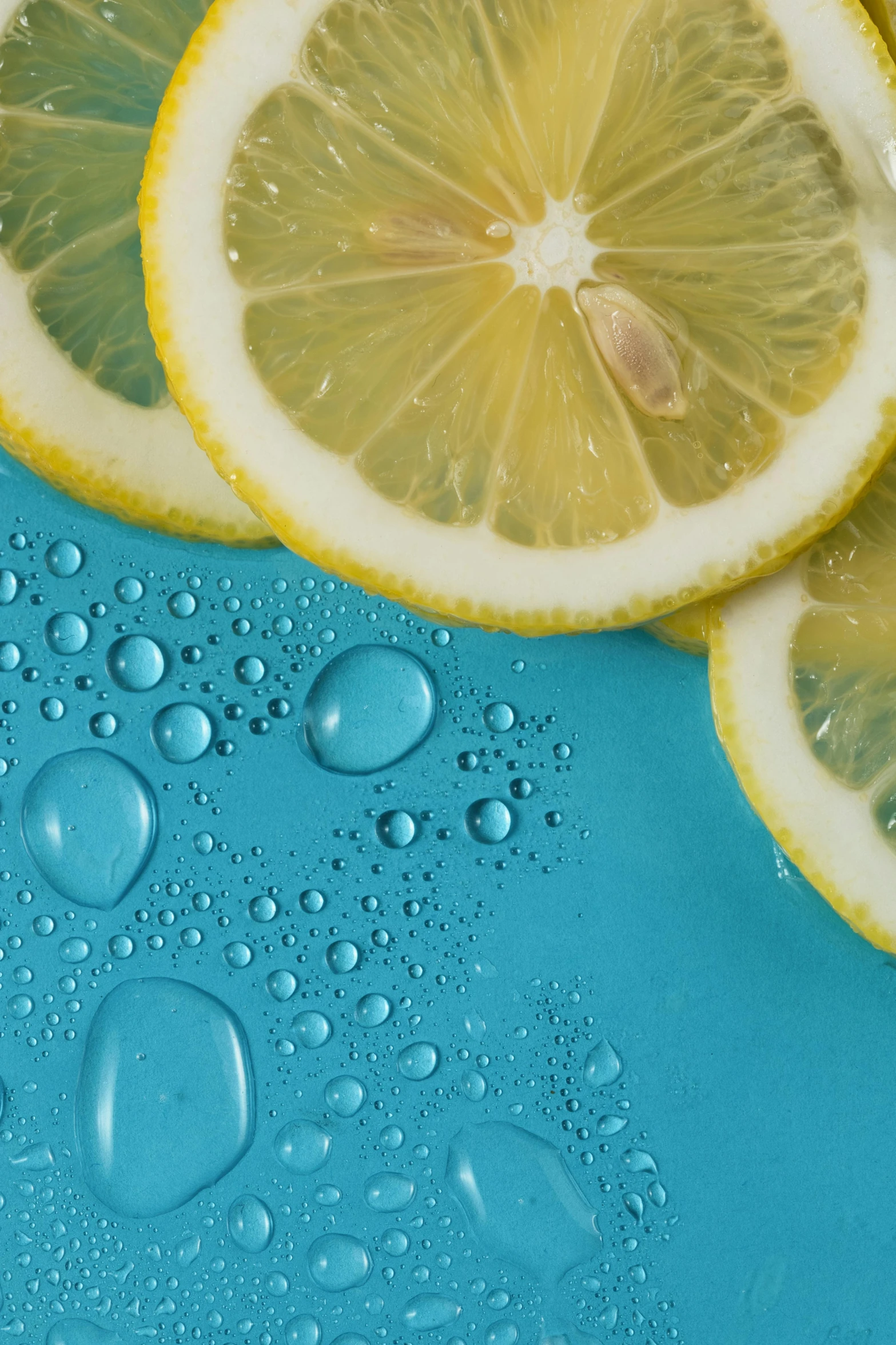 sliced lemons on blue surface with bubbles