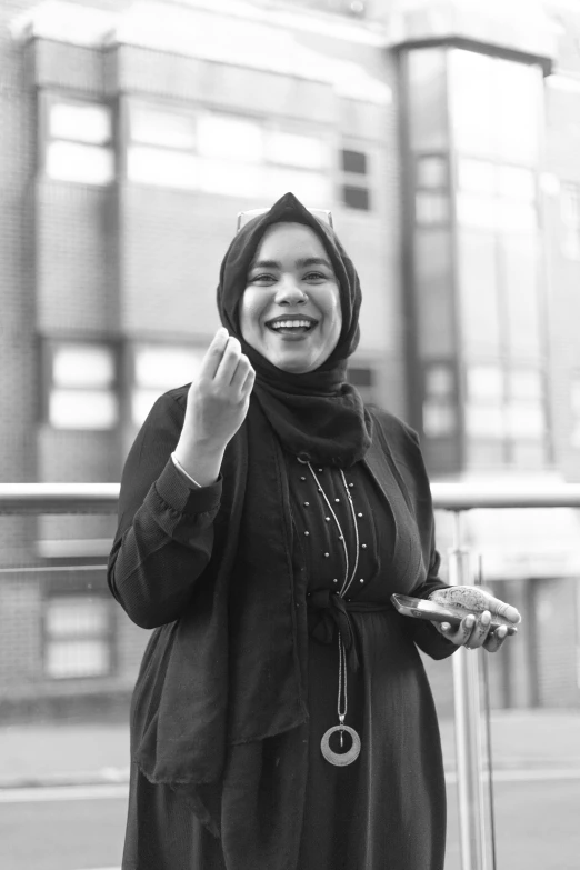 the woman is standing in front of a building smiling