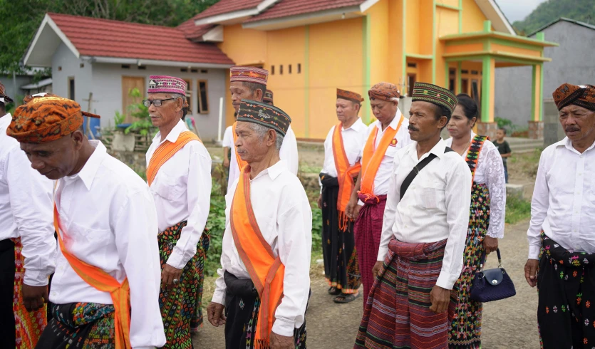 the group of people wearing ethnic clothing are looking at soing