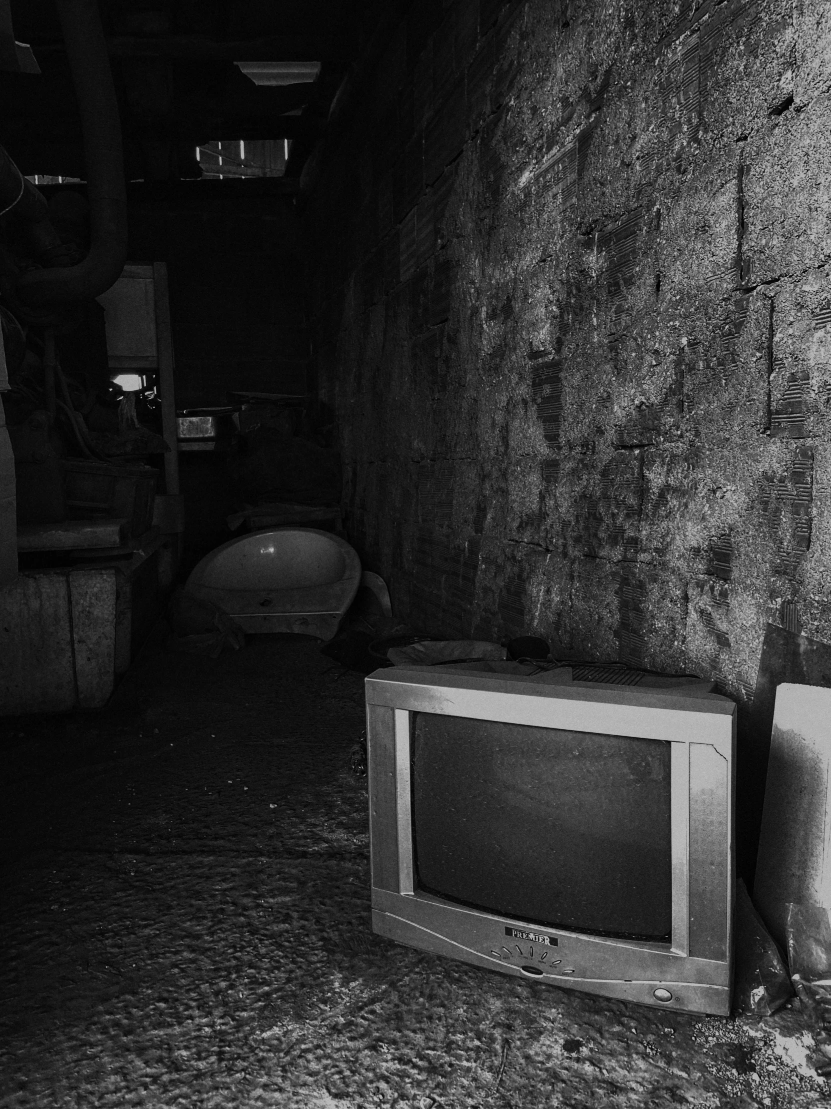 two small tvs and a boat sit in a dark alley