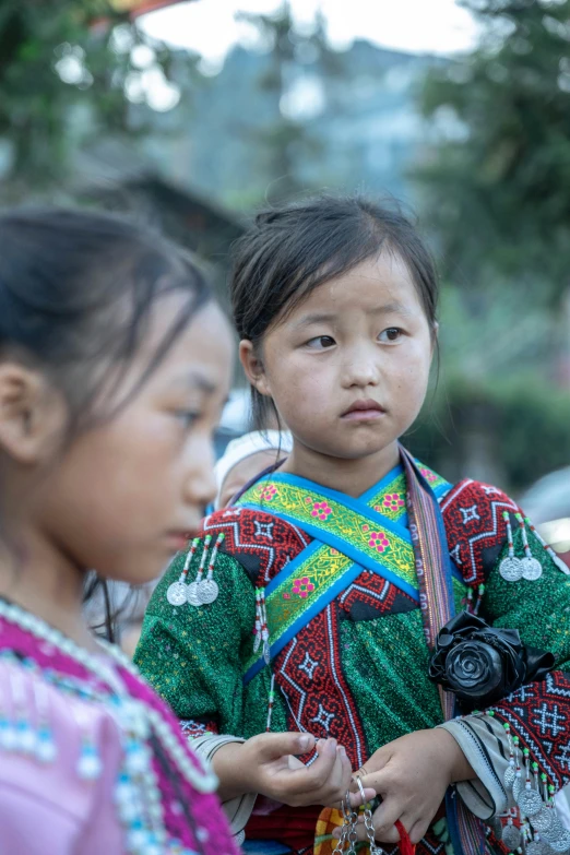 two young indian girls standing outside on a street