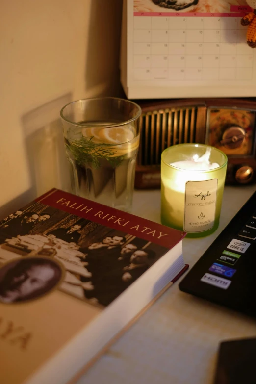 candles and book are setting on a desk