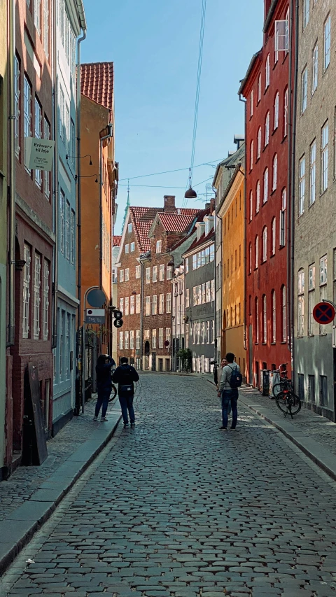 people walking along an old cobble stone street