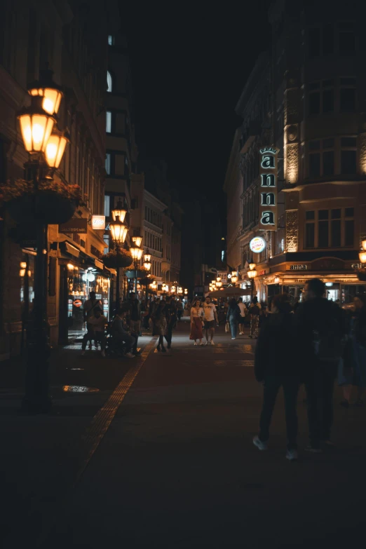 people are walking on a sidewalk near some stores