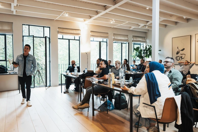 a group of people standing around a room filled with tables